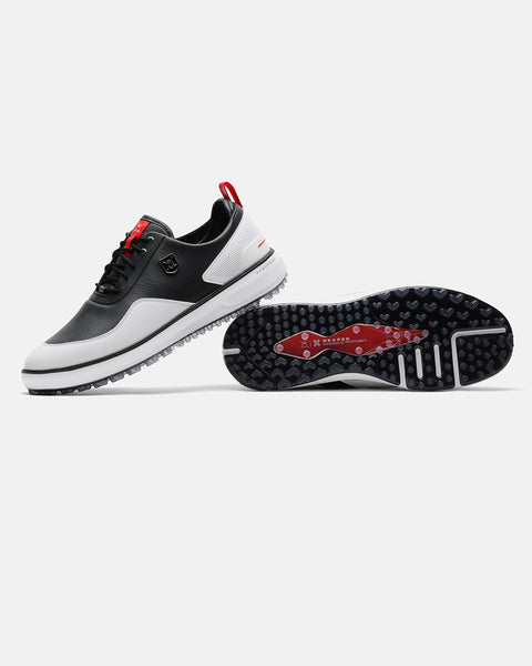 Product image of the Black-White Ghost Golf Reaper golf shoes, with one shoe resting on its side to display the outsole and the other showing the left-side profile with its heel placed on top of the first shoe. #color_black-white