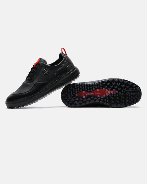Product image of the Black Ghost Golf Reaper golf shoes, with one shoe resting on its side to display the outsole and the other showing the left-side profile with its heel placed on top of the first shoe. #color_black