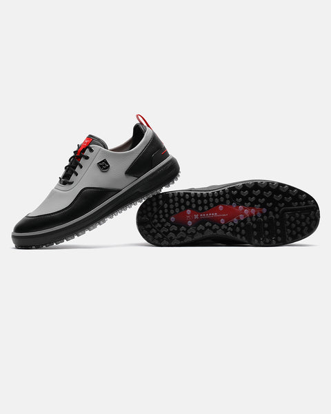 Product image of the Grey Ghost Golf Reaper golf shoes, with one shoe resting on its side to display the outsole and the other showing the left-side profile with its heel placed on top of the first shoe. #color_grey