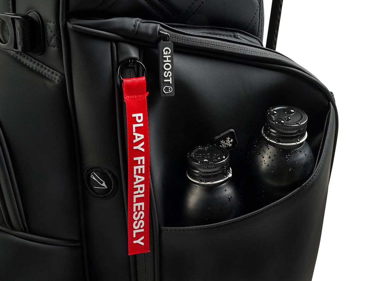 Black Golf bag with a red 'PLAY FEARLESSLY' tag and water bottles inside