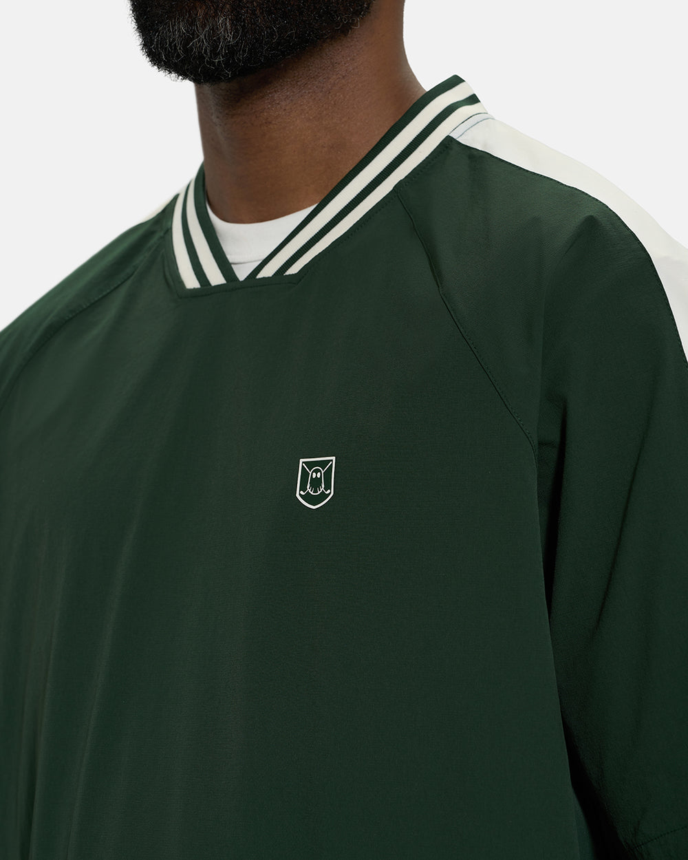 Front Closeup View of Bogey Green Fairway Windshirt V2 on Black Male Model with Ghost Icon Crest #color_bogey-green