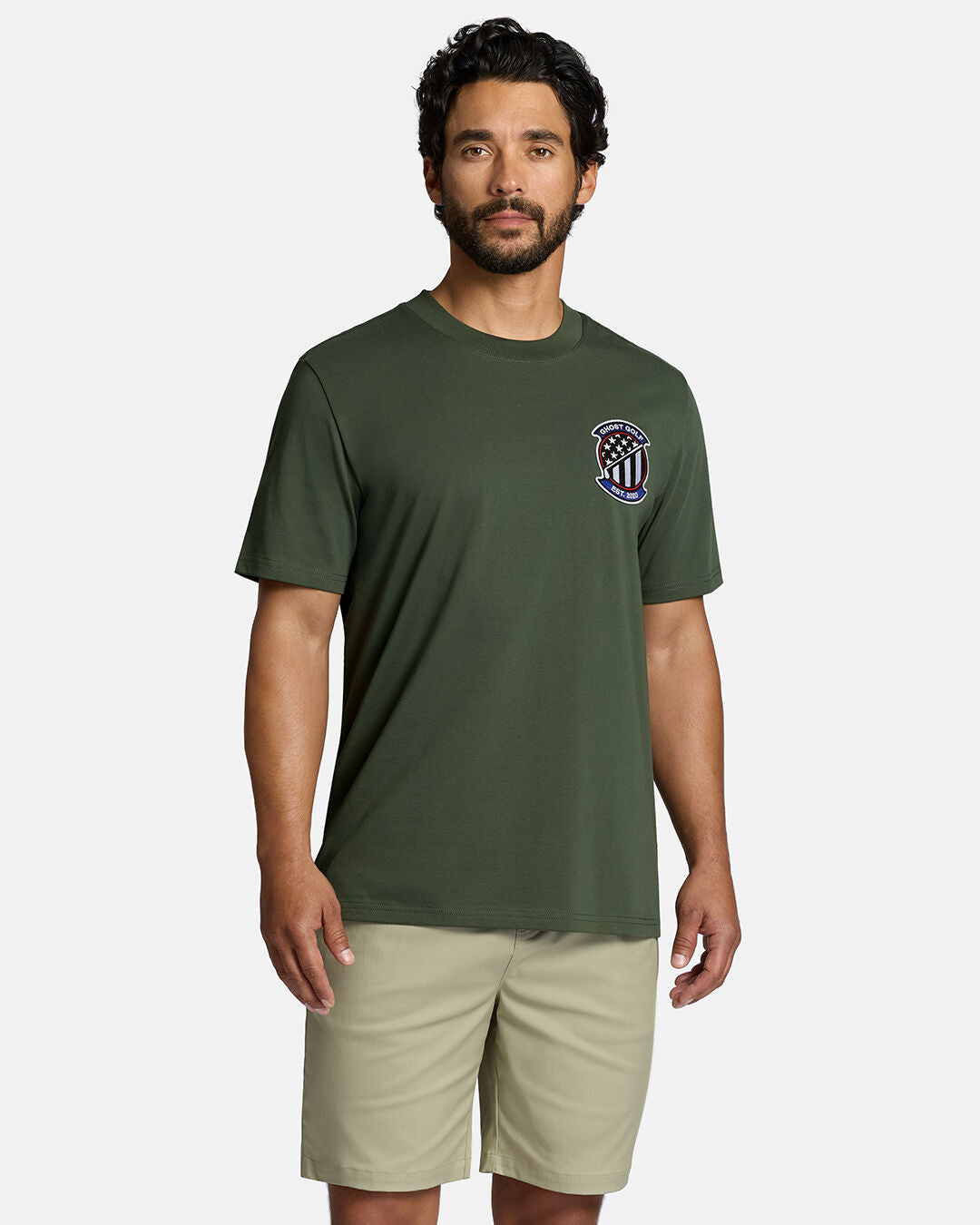 Top Front Body Shot of White Male Model Wearing Forest Shadow Flag Tee with khaki shorts. Ghost Golf Hit on the left front chest #color_forest-shadow