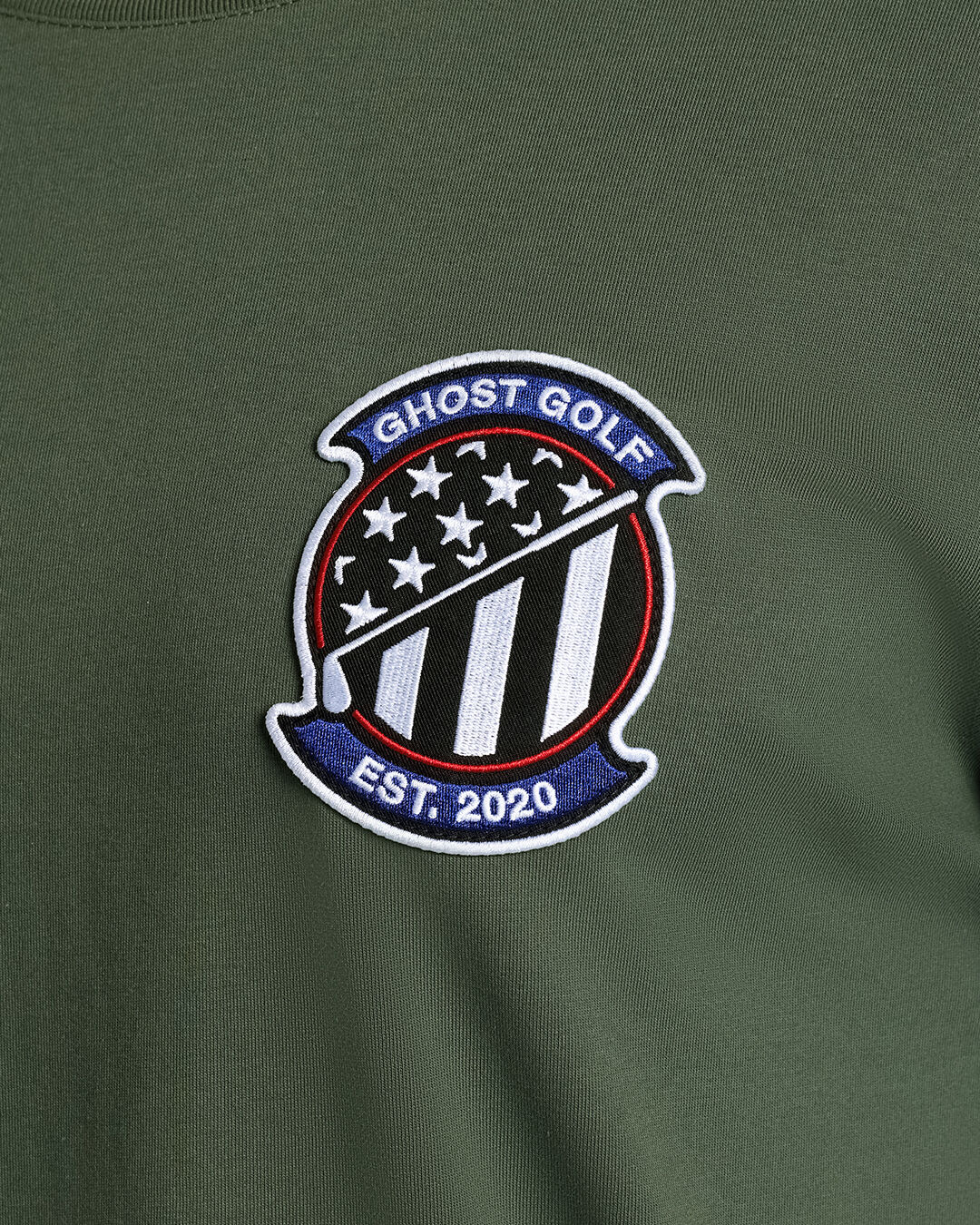 Closeup Shot of Forest Shadow Flag Flight Tee showcasing front emblem graphic Ghost Golf Hit #color_forest shadow