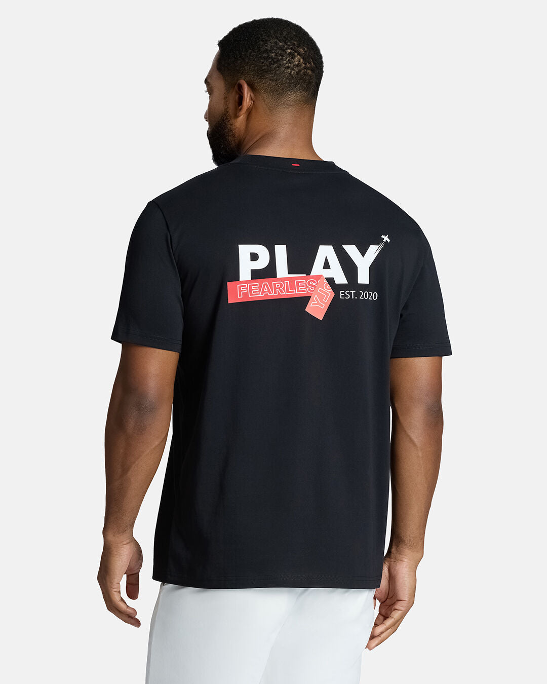 Top Back Body Shot of Black Male Model Wearing Black Flight Tee with white shorts. Play Fearlessly hit on the back #color_black