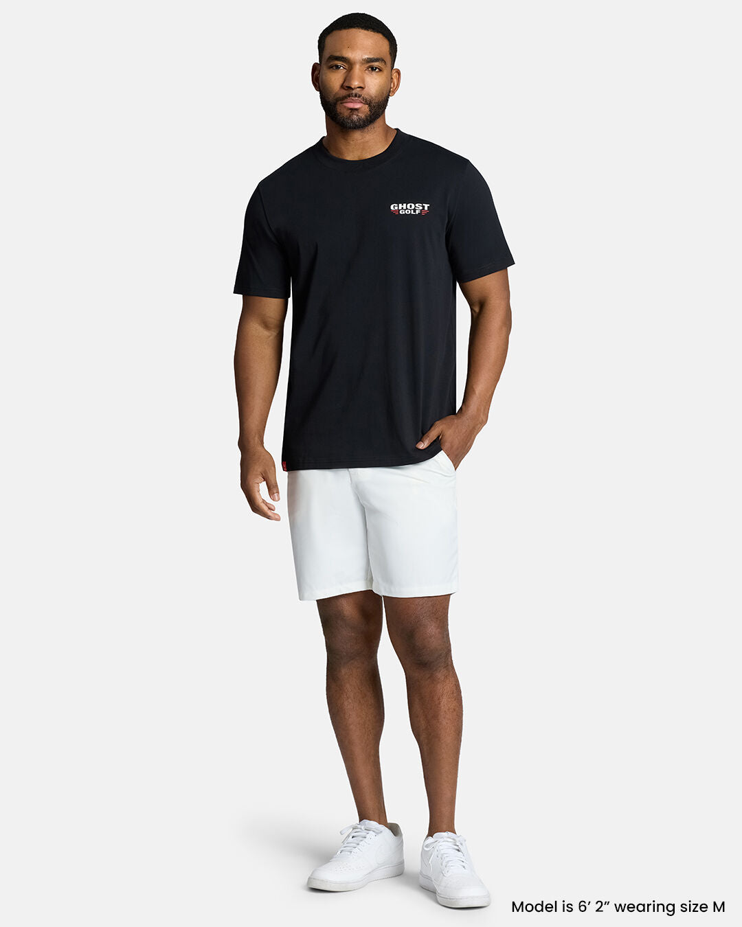 Full Front Body Shot of Black Male Model Wearing Black Flight Tee with white shorts and white shoes #color_black
