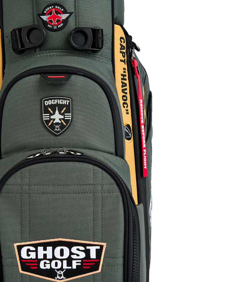 Close-up detail shot of the G-Suit Anyday Bag showcasing the magnetic rangefinder pocket. Features a badge-style front patch with a fighter jet icon and "Dogfight" text. Detailed product image highlighting the premium materials, functional magnetic closure, and aviation-inspired Ghost Golf design elements.