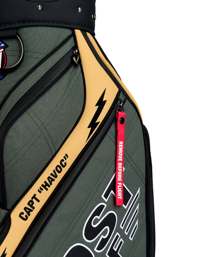 Detail shot of the G-Suit Staff Bag showcasing the signature red "Remove Before Flight" tab and Capt Havoc branding. Close-up image highlighting the premium materials, embroidered details, and aviation-inspired design elements.