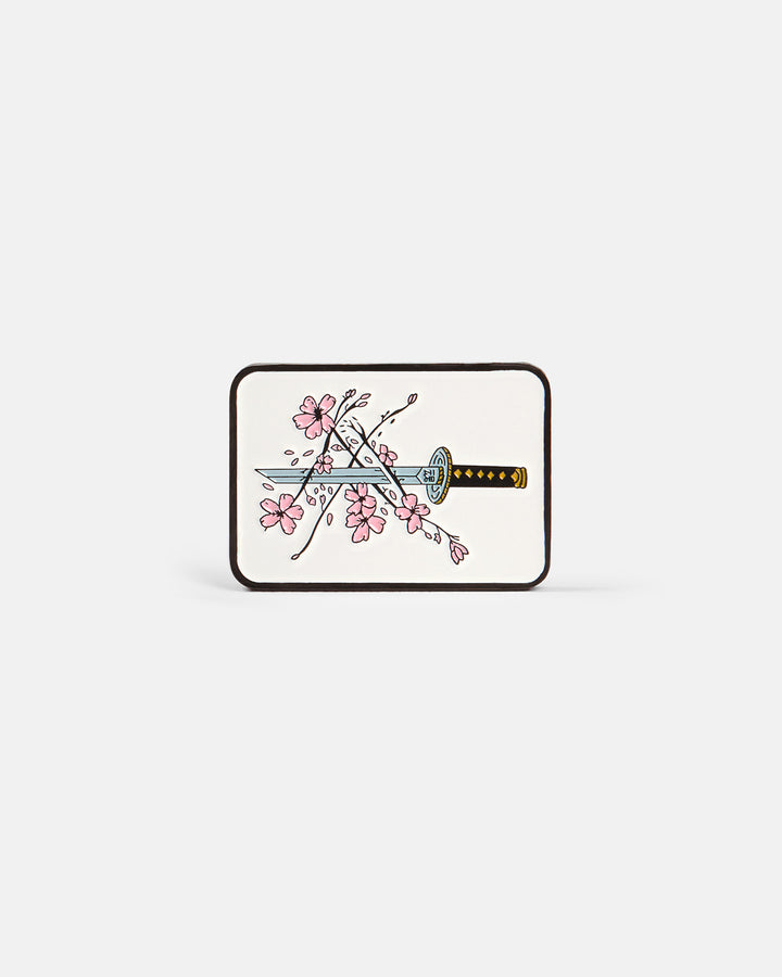 Product photo of a rectangular ball marker featuring a katana and cherry blossom design on an off-white background.