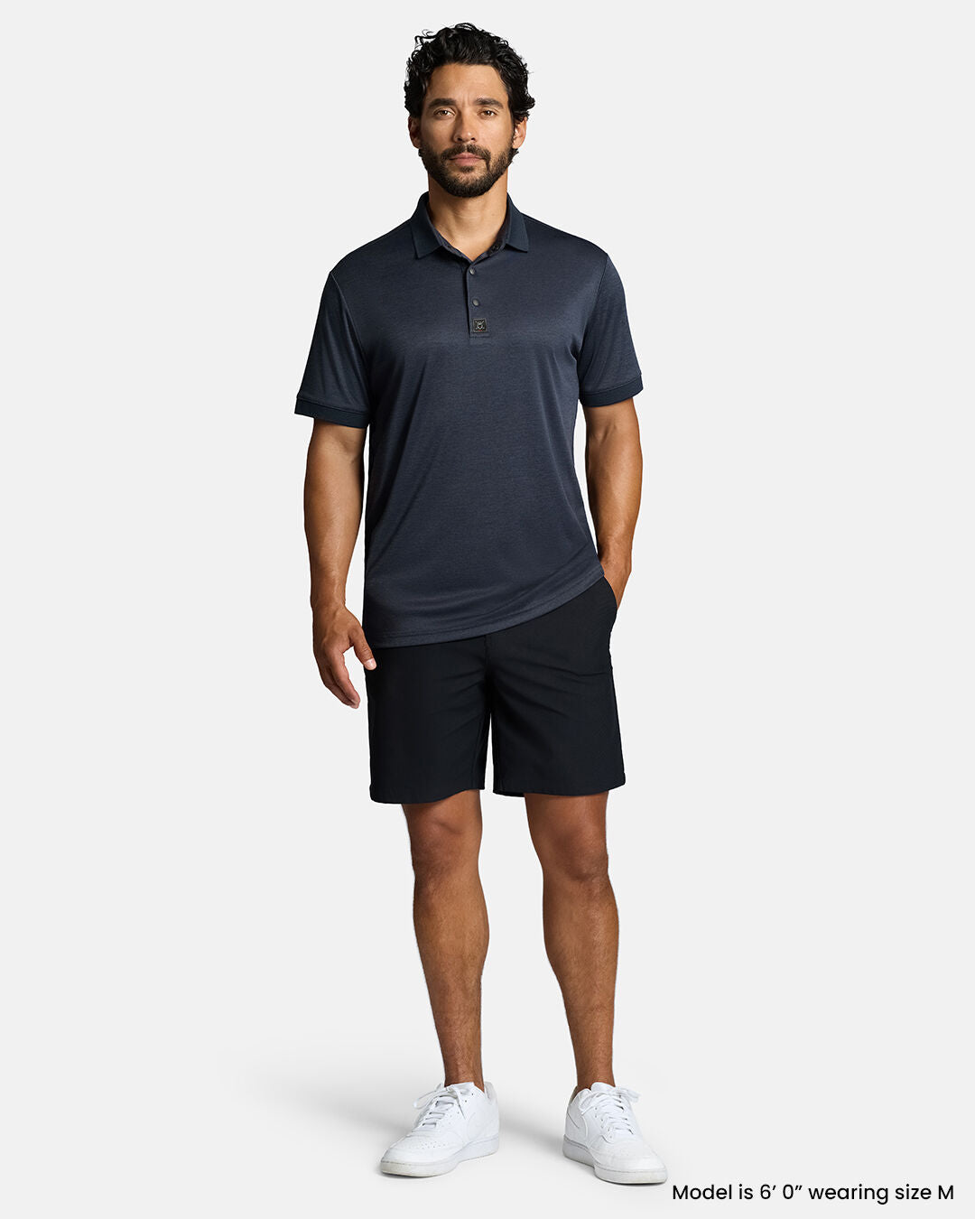 Full Front Body Shot of White Male Model Wearing Dark Navy Marled Core Polo with navy shorts and white shoes #color_dark-navy