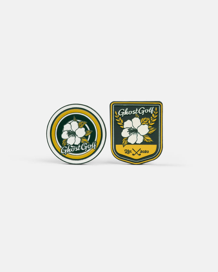 Product photo featuring two ball markers with a Patrons Only theme, each showcasing the Ghost Golf branding and azalea-inspired design elements.