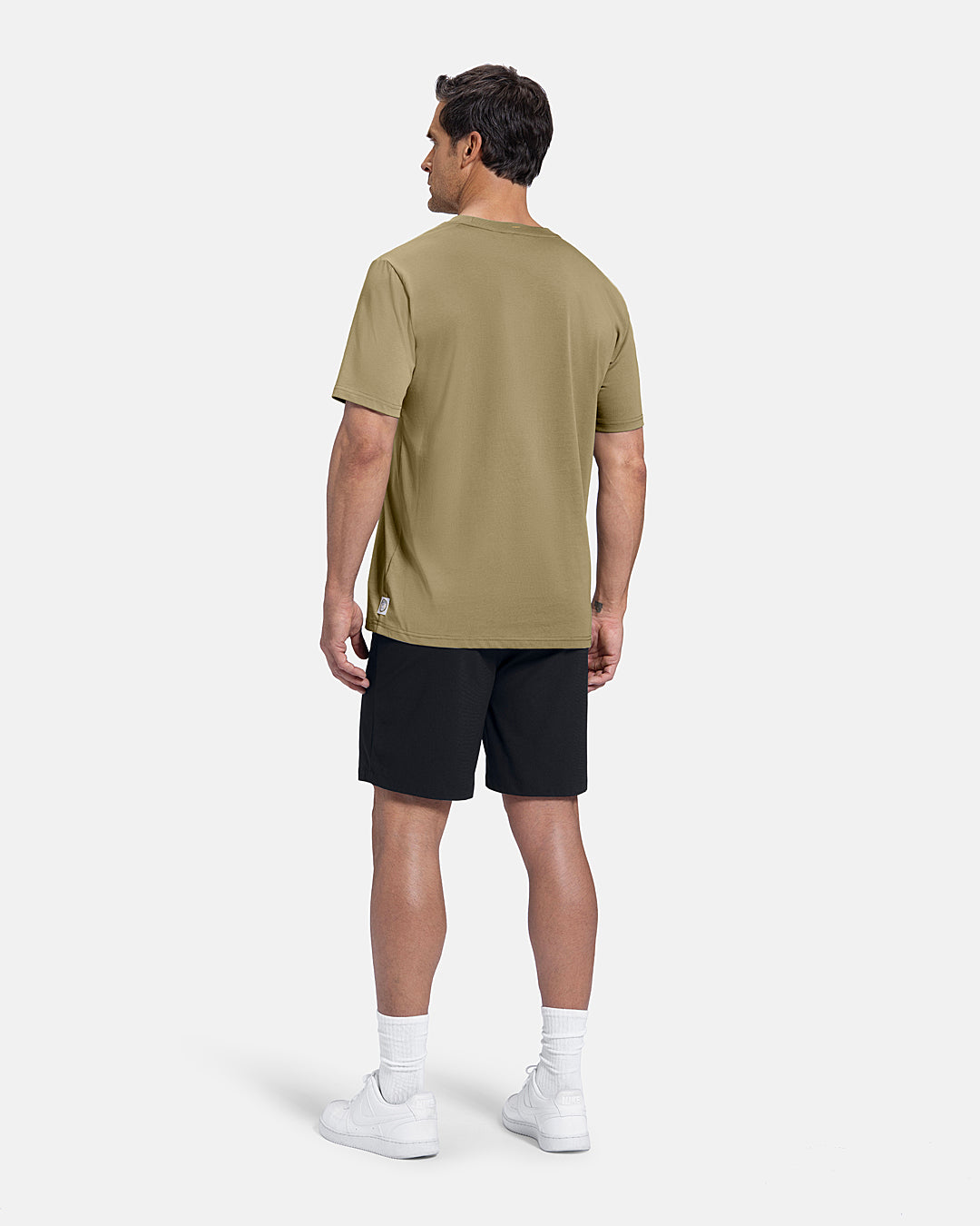 Full Body Back View of Sand Patrons Azalea Club Badge Tee on white male model wearing black shorts and white shoes #color_sand