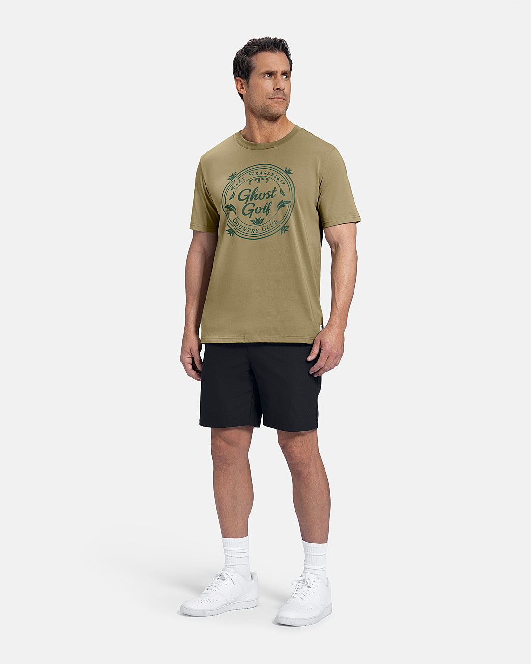 Full Body Front View of Sand Patrons Club Badge Tee on white male model wearing black shorts and white shoes #color_sand