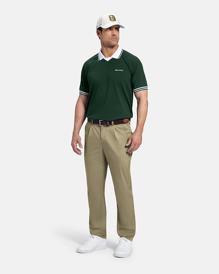 Full Body Front View of Bogey Green Patrons Heritage Polo on white male model wearing beige pants and white shoes brown belt and hat with polo tucked in pants #color_bogey-green
