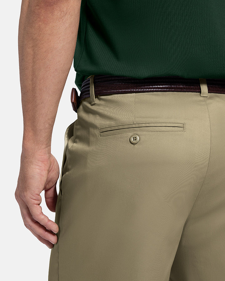 Closeup Back View of Sand Patrons Pleated Short on white male model with green polo tucked in wearing brown belt #color_sand