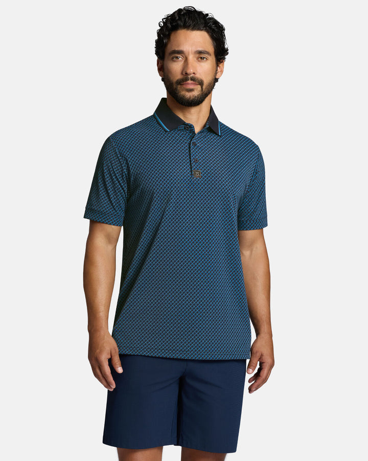 Top Front Body Shot of White Male Model Wearing Dark Navy Qualifier Chase Polo with navy shorts. Polo is untucked #color_dark-navy