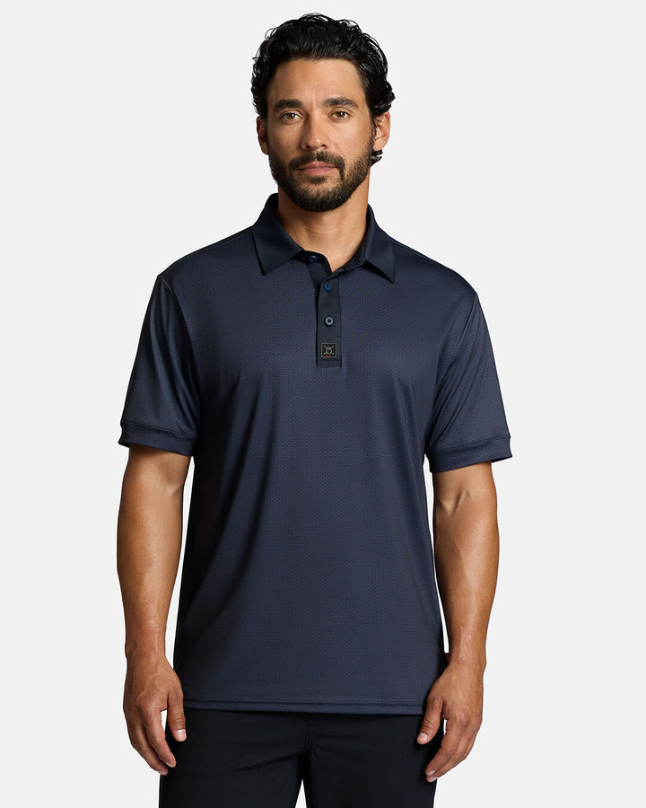 Top Front Shot of White Male Model Wearing Dark Navy Qualifier Grid Polo with polo untucked in black pants wearing #color_dark-navy
