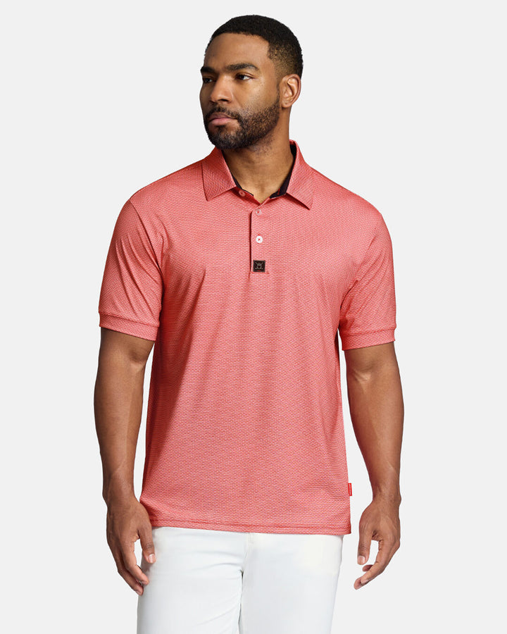 Top Front Shot of Black Male Model Wearing Red Qualifier Grid Polo untucked wearing white pants #color_red