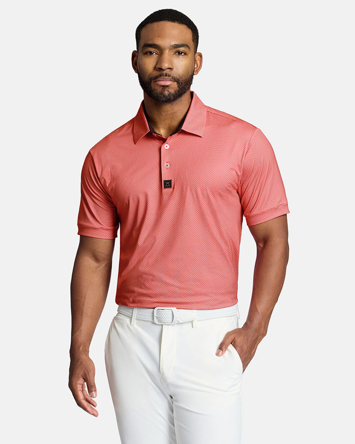 Top Front Shot of Black Male Model Wearing Red Qualifier Grid Polo tucked in white pants wearing white belt. #color_red
