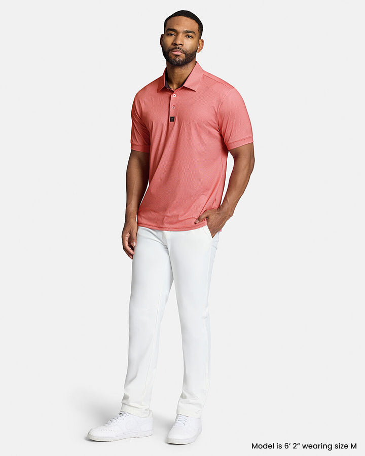 Full Body Front Shot of Black Male Model Wearing Red Qualifier Grid Polo with white pants and white shoes. Polo is untucked. #color_red