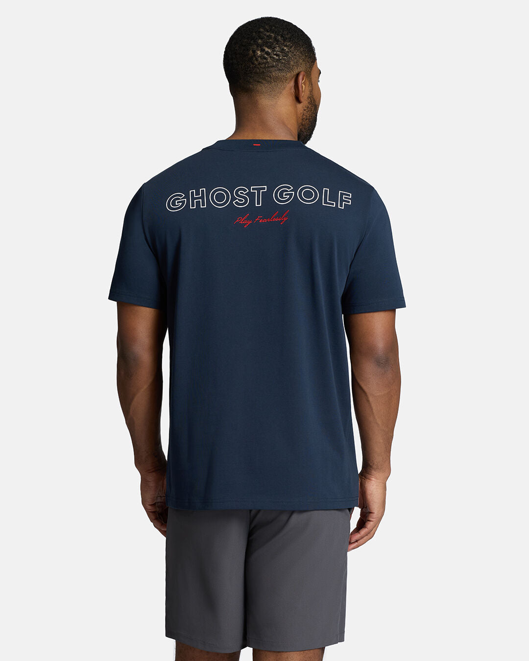 Top Back Body Shot of Black Male Model Wearing Dark Navy Qualifier Player Tee show casing typographic design on the back. Model is wearing grey shorts #color_dark-navy