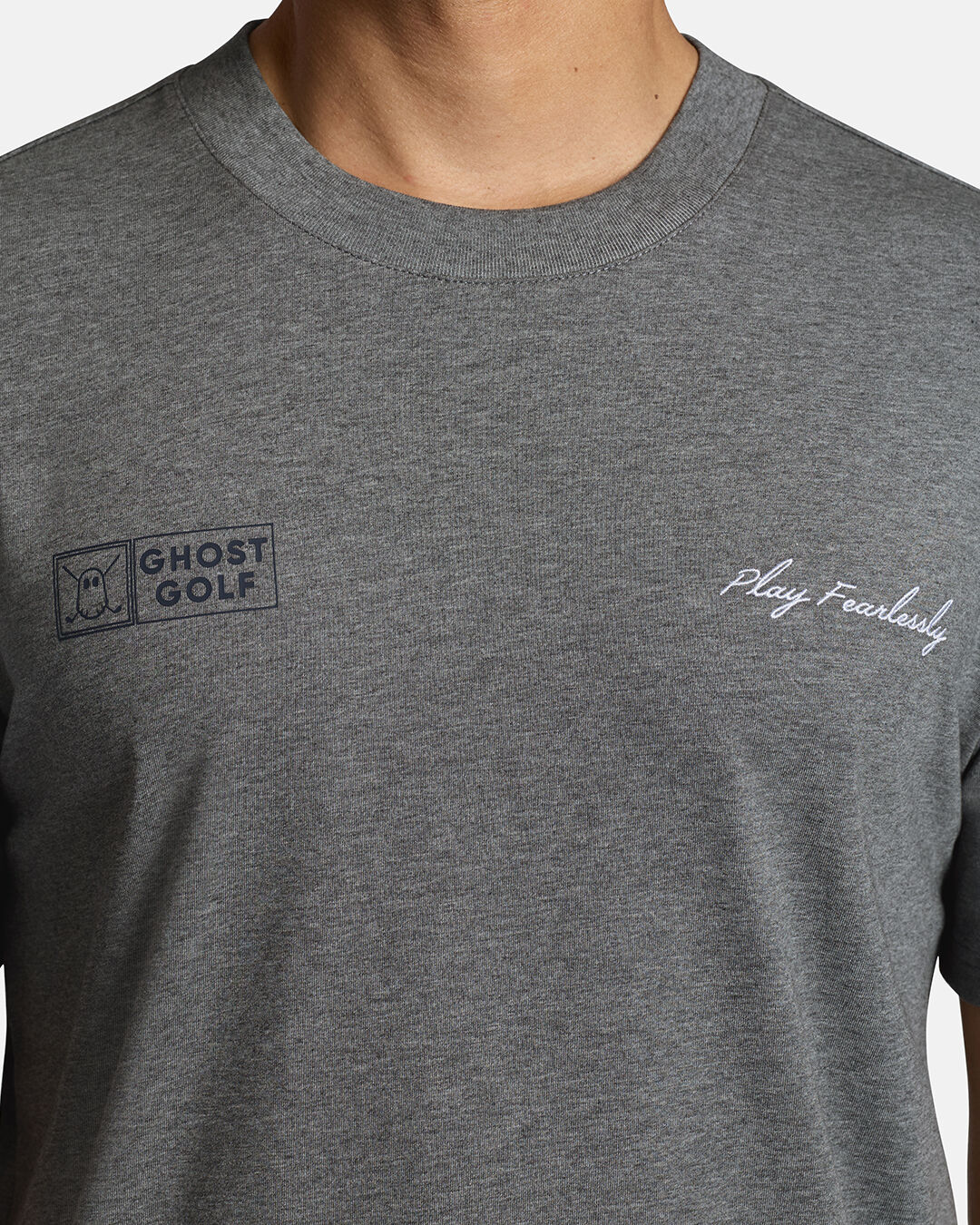 Closeup Shot of Grey Qualifier Player Tee showcasing play fearlessly on left chest and ghost golf on right on chest #color_heather-grey