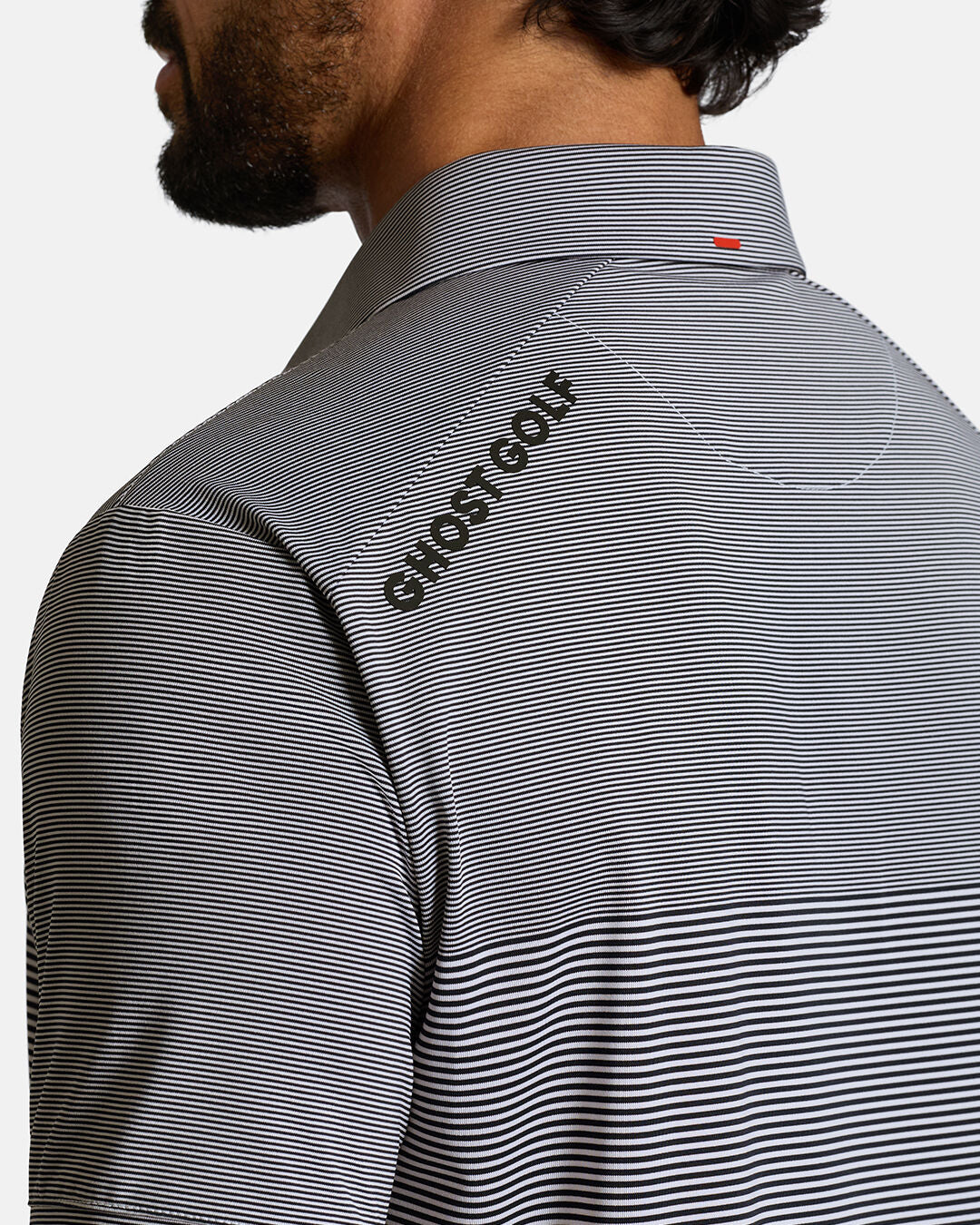 Closeup Back Shoulder Shot of White Qualifier Stripe Polo back of the polo showcasing ghost golf hit on left back shoulder #color_dark-navy