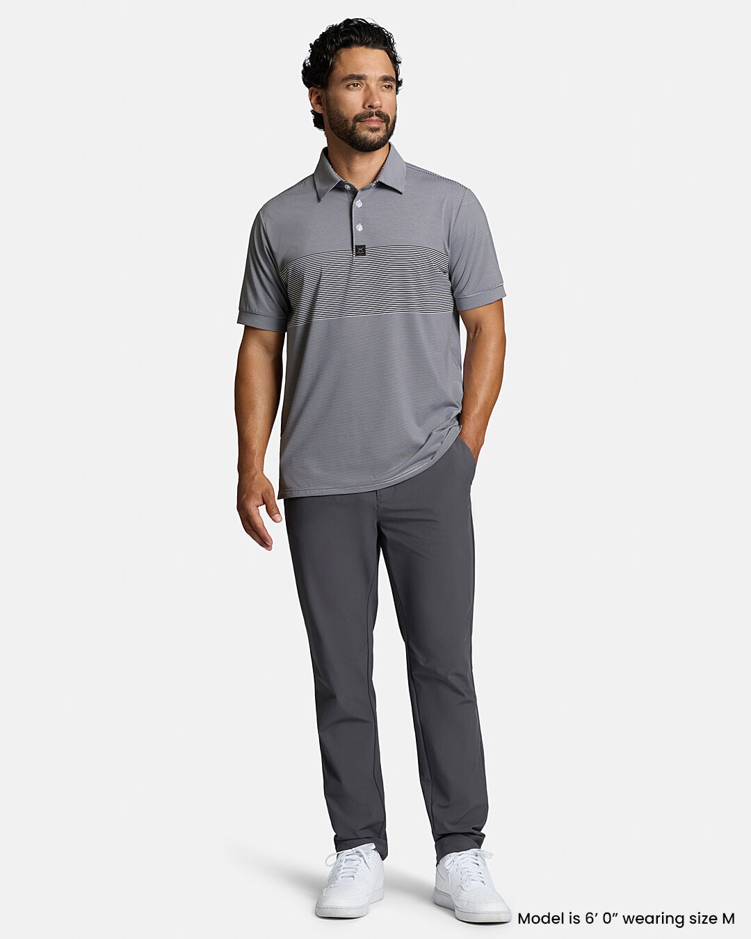 Full Front Body Shot of Dark Navy Male Model Wearing Grey Qualifier Stripe Polo with grey pants and white shoes #color_dark-navy