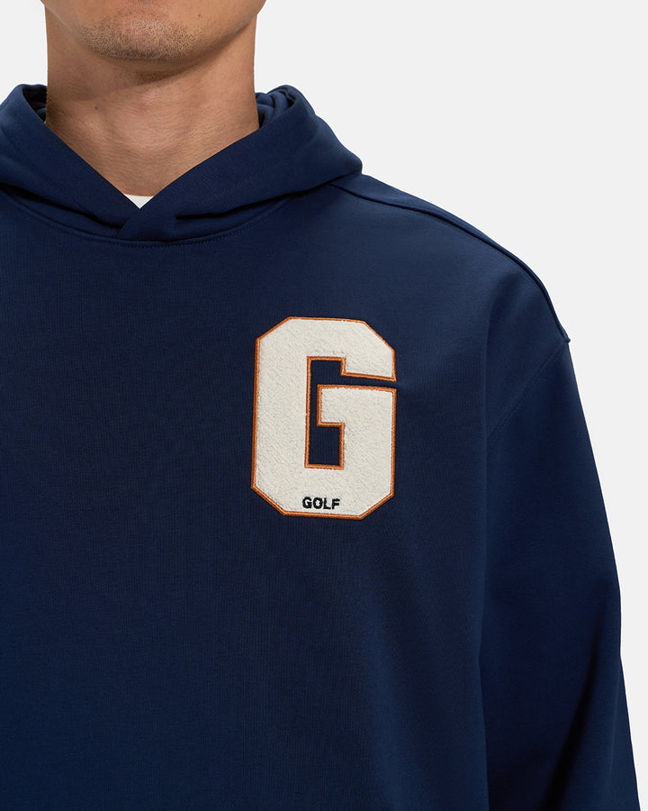 Front Closeup View of Navy Spectator Hoodie on Asian Male Model with letter G chest Hit  #color_navy