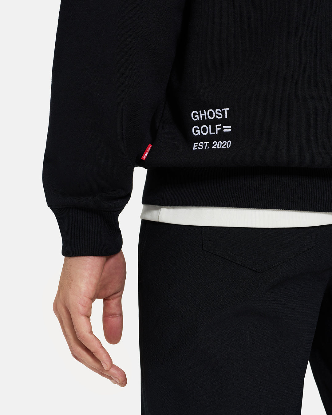 Bottom Closeup View of Black Spectator Raglan Sweatshirt on Asian Male Model with embroidered Ghost Golf #color_black