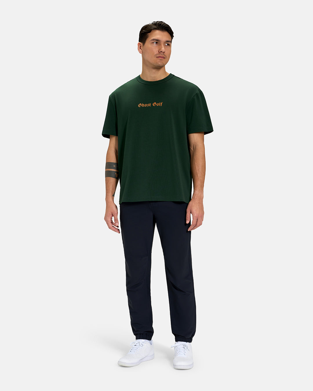 Full Body Front View of Bogey Green Spectator Tee on Asian Male Model wearing navy pants and white shoes #color_bogey-green