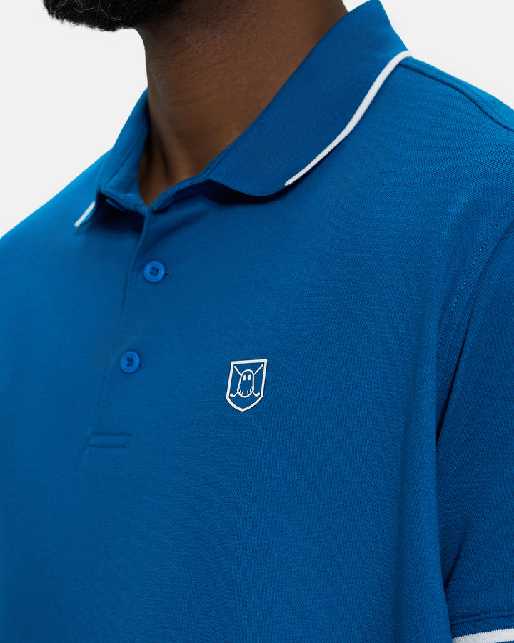 Front Closeup View of Royal Blue Spectator Tipped Collar Polo on Black Male Model with Ghost Icon Crest #color_royal-blue