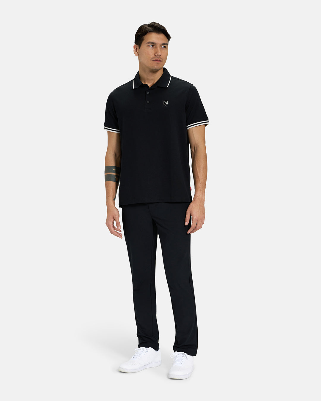 Full Body View of Black Spectator Tipped Collar Polo on Asian Male Model wearing black pants and white shoes #color_black