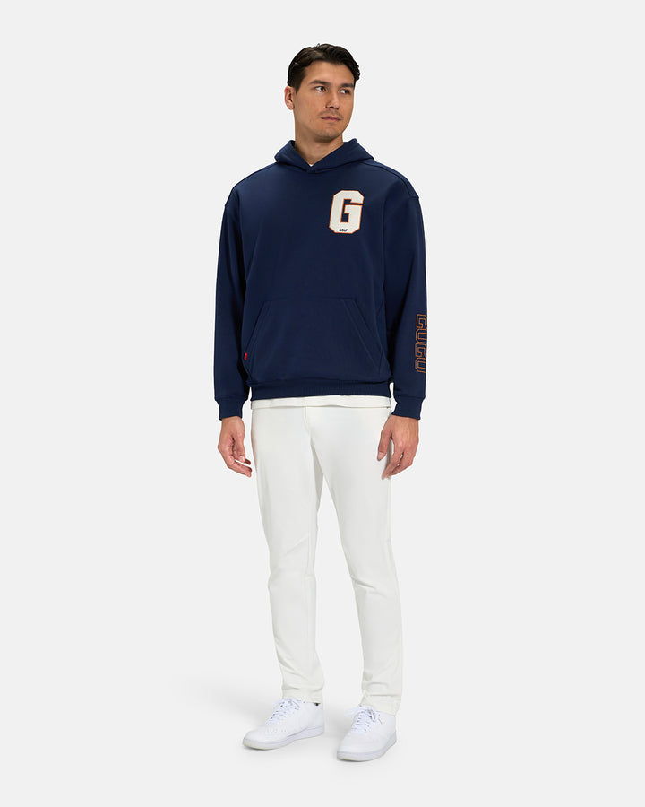Full Body View of Navy Spectator Hoodie on Asian Male Model wearing white tee white pants and white shoes with letter G on chest #color_navy