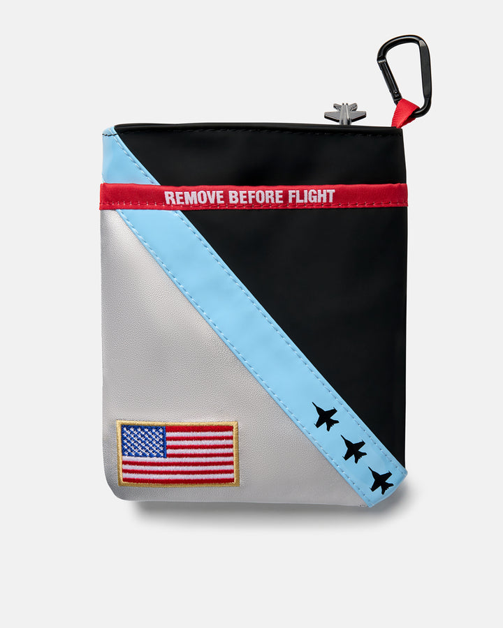 Back product shot of the Striker Utility Pouch featuring a USA flag patch in the bottom-left corner and "Remove Before Flight" text centered near the top. Rear-facing view highlighting the pouch’s military-inspired design details and branding elements.