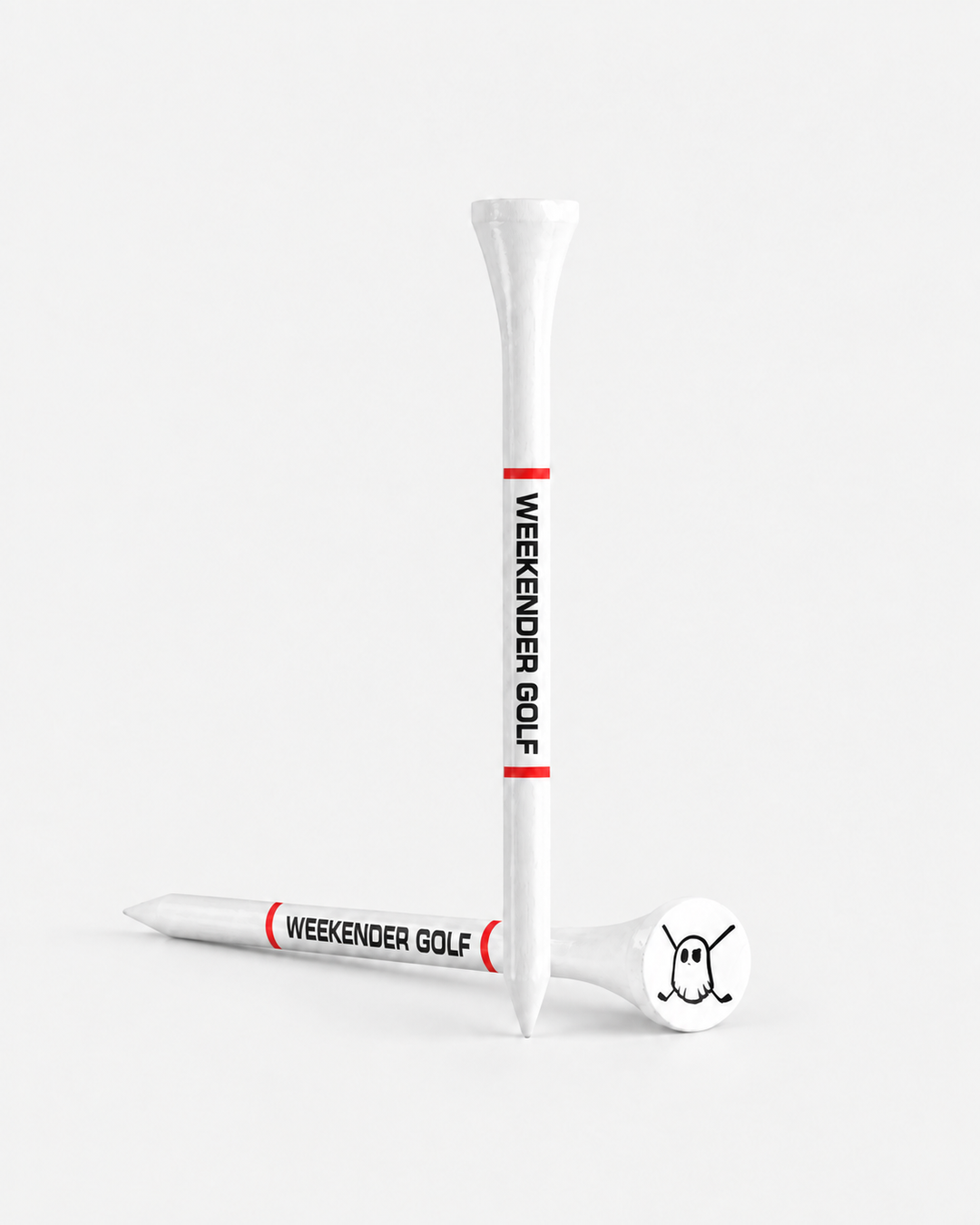 Two white tees with red bands and black 'WEEKENDER GOLF' text, shown on a clean light gray studio background. One tee is upright and one lies on its side, with a white club head resting on the tee base.