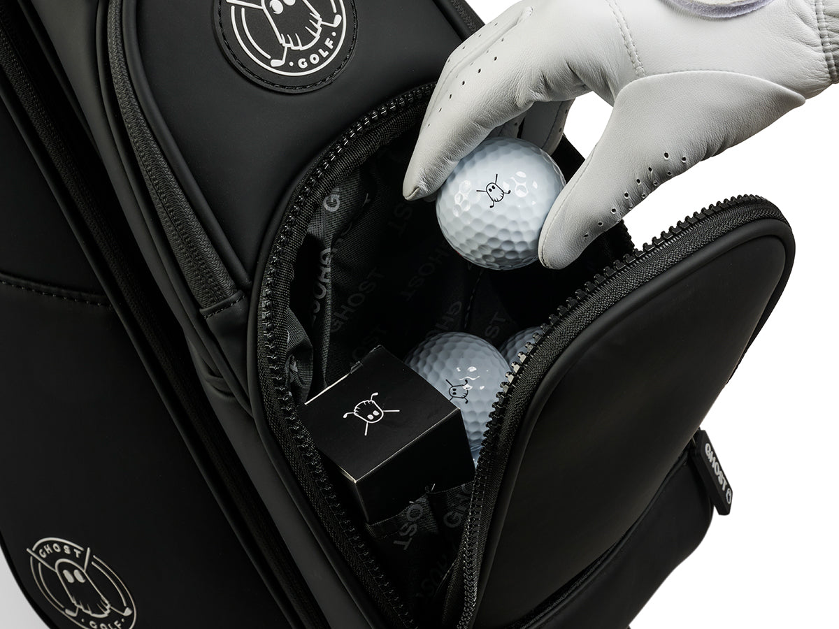 Golf bag with golf balls and a glove, featuring a brand logo.