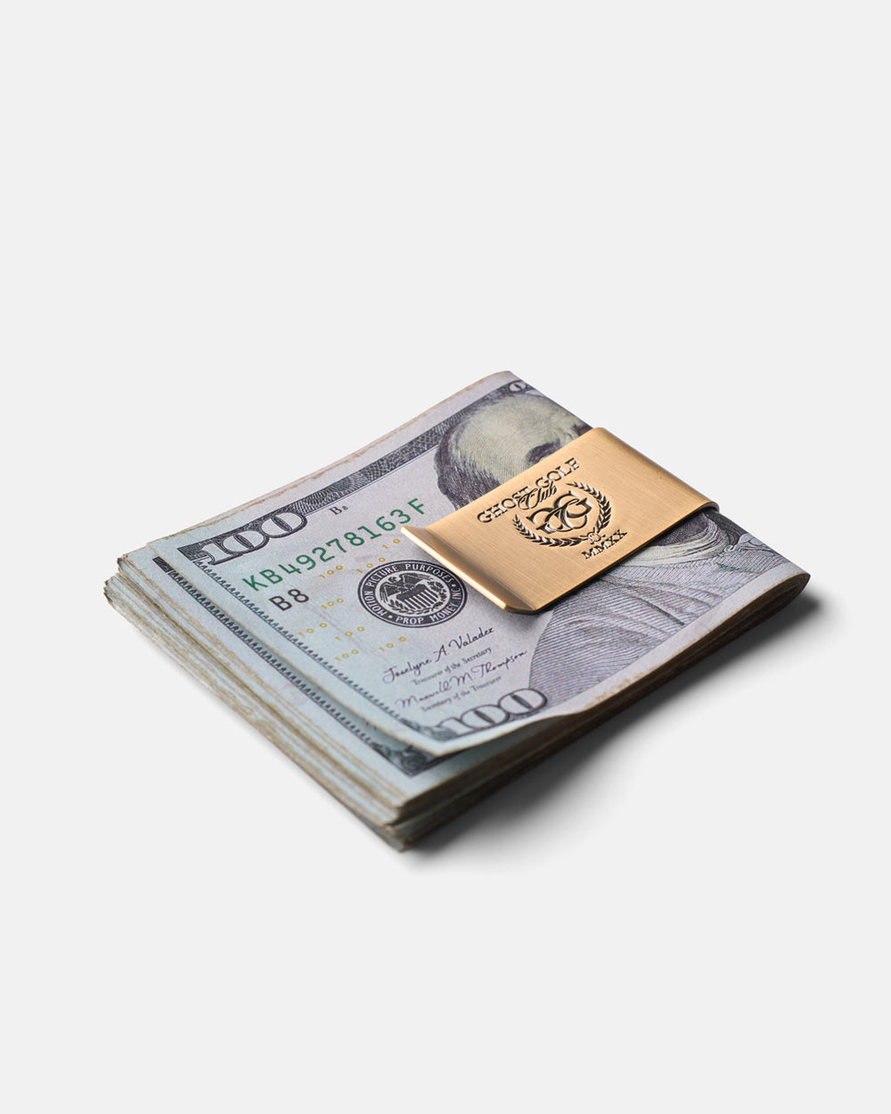 Three-quarter view of a money clip holding a neatly folded stack of cash.